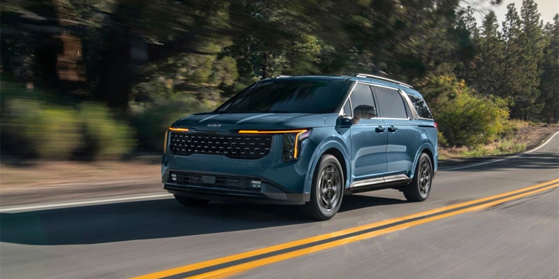 2025 Kia Carnival driving in the woods